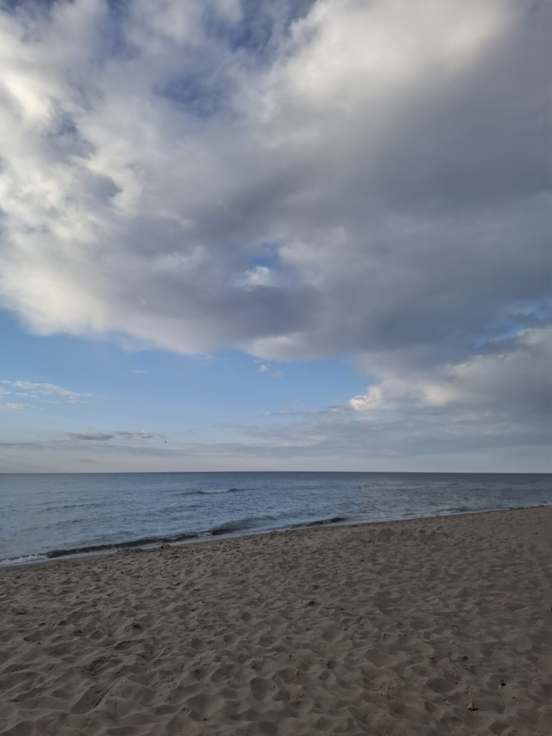 Plaża i spokojne morze pod zachmurzonym niebem